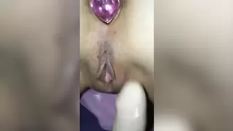 Fondling her vagina with a booty plug